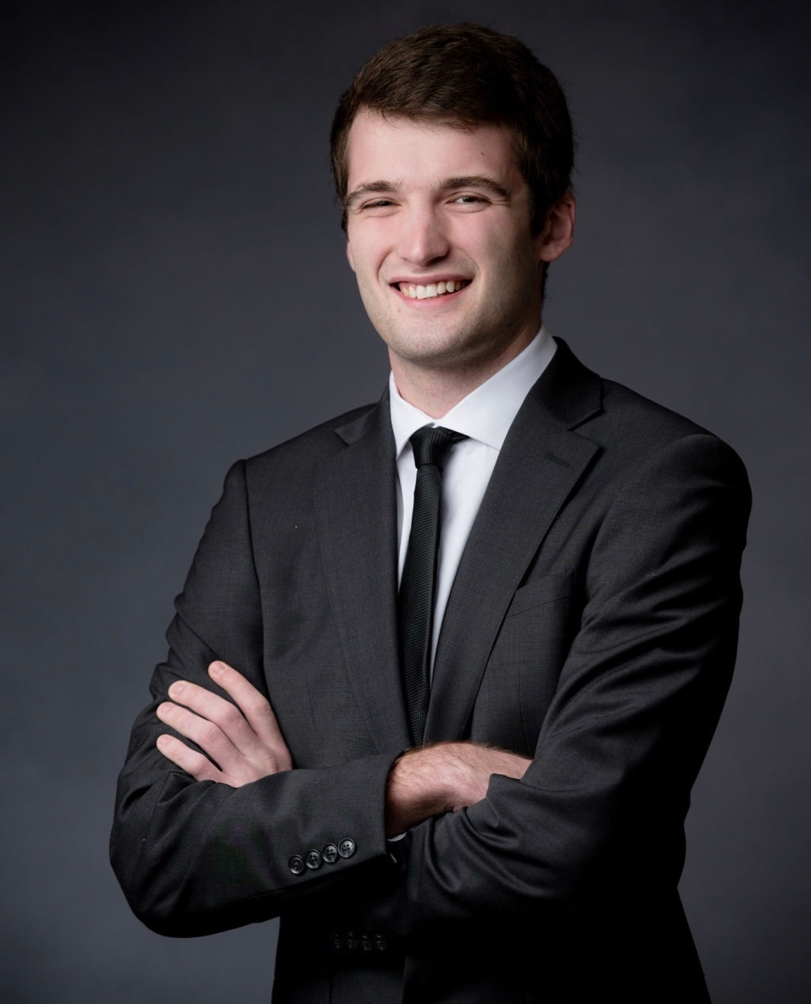 A photo of Luke Ortolani's headshot, wearing a suit